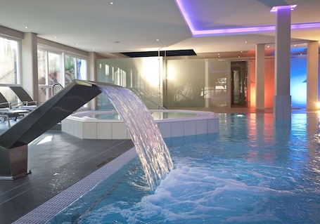 Una piscina cubierta, tumbonas. Hotel St Georg