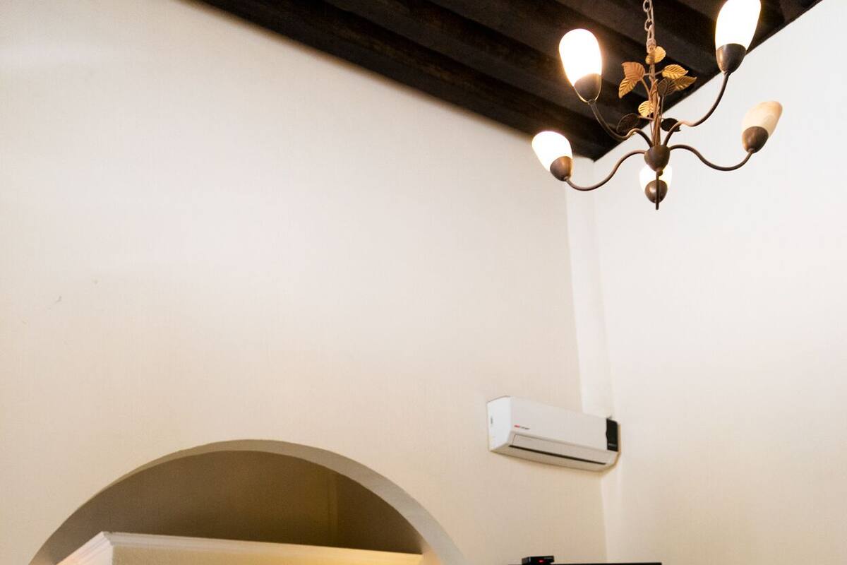 Una habitación compacta con cocina integrada, televisor de pantalla plana y sofá.