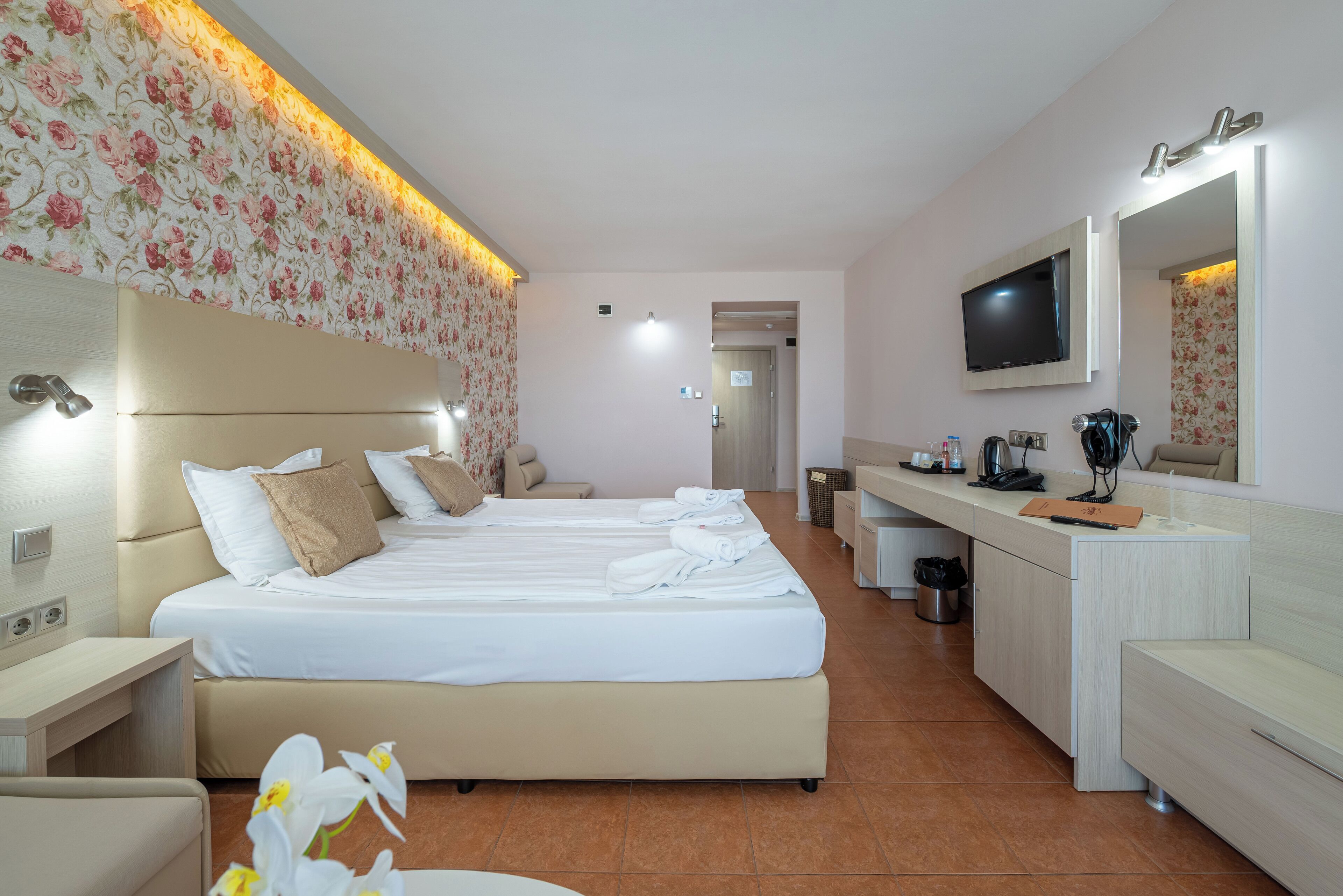 Una habitación de hotel con una cama grande, televisión, escritorio y baño.