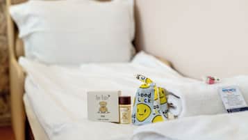 Cozy retreat with a plush bed, adorned with a thoughtful 'Hey Baby' gift and a sweet 'Good Luck' towel.