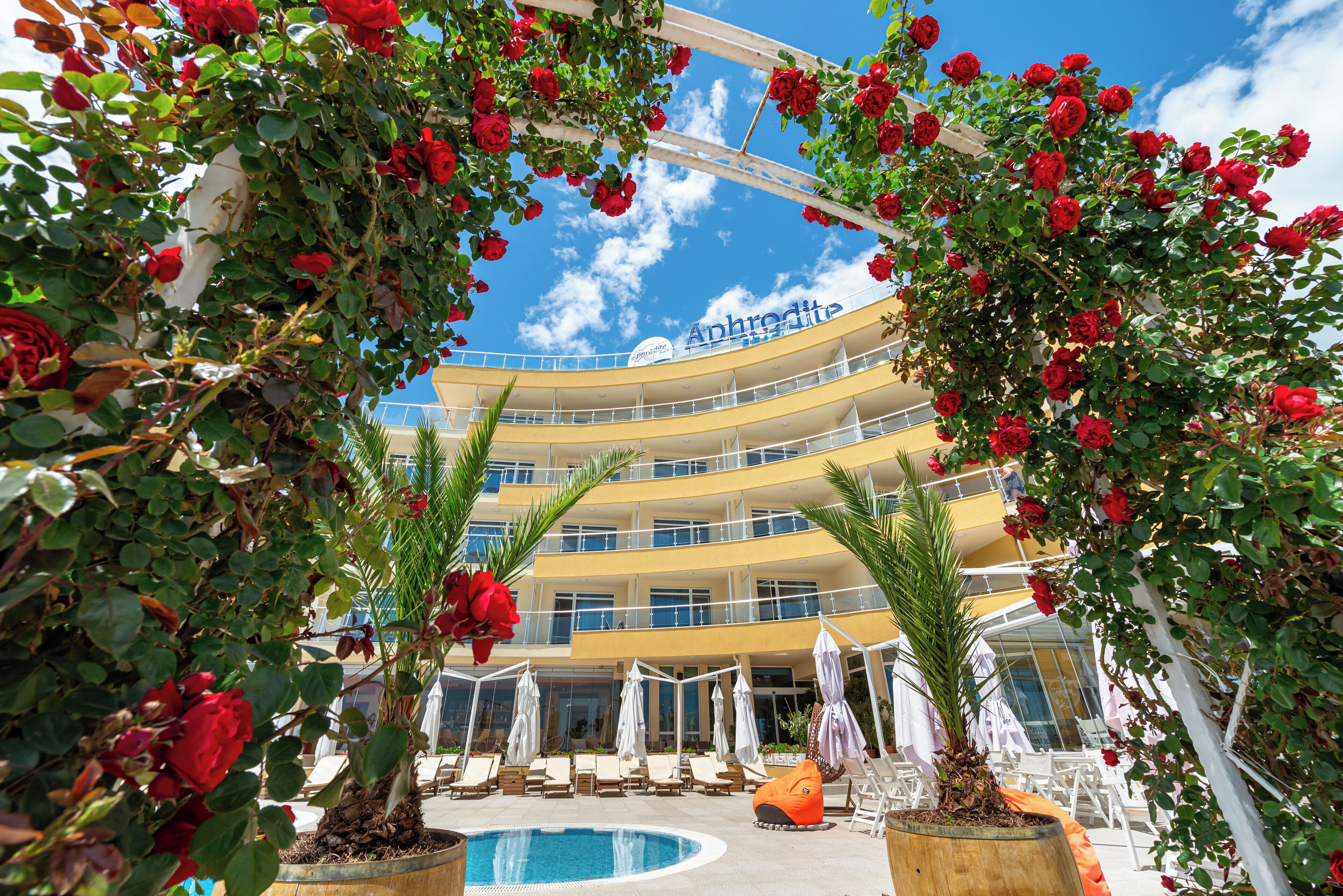 Un hotel de varios pisos con balcones y una zona de piscina.