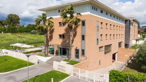 Un hôtel moderne doté d’un toit plat, de nombreuses fenêtres et d’une enseigne indiquant « ARDEATINA PARK HOTEL ».