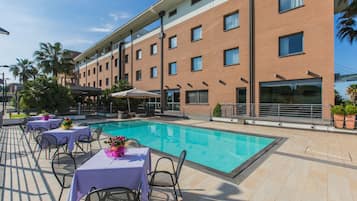 Een seizoensgebonden buitenzwembad, parasols voor strand/zwembad