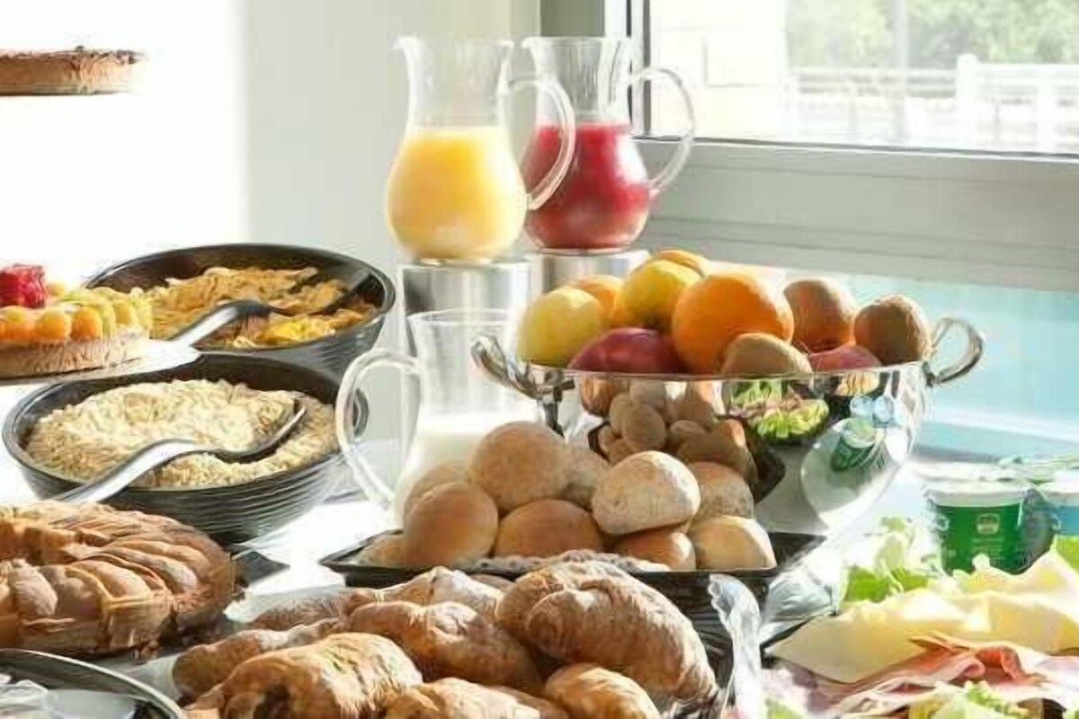 A breakfast buffet with various food items, including fruits, pastries, and beverages.