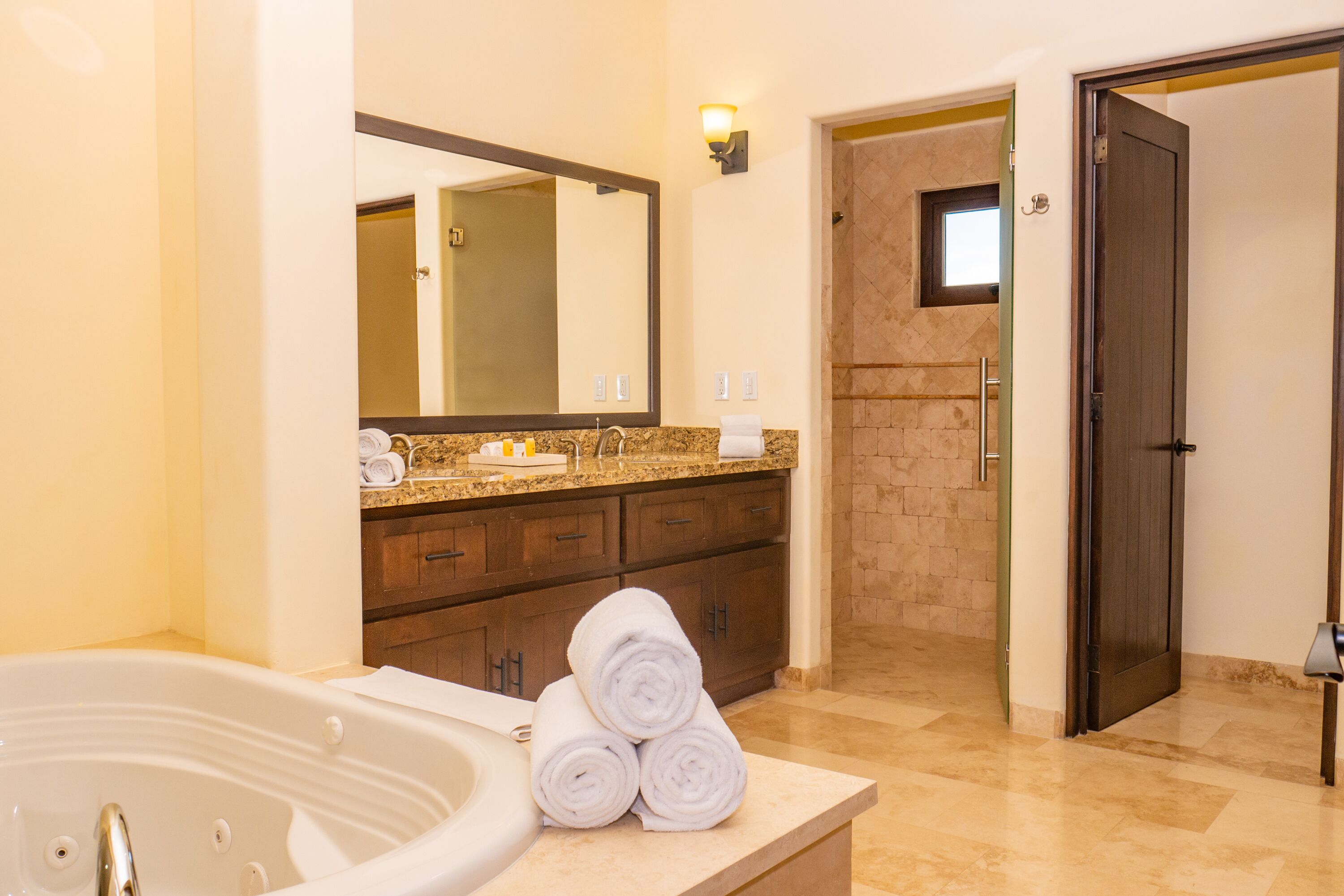Un baño moderno con una bañera grande, un tocador con espejo y una zona de ducha.