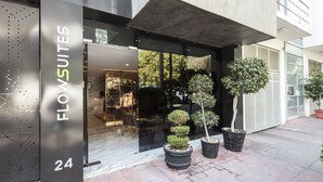 Un bâtiment moderne avec une enseigne indiquant « FLOW SUITES 24 ».