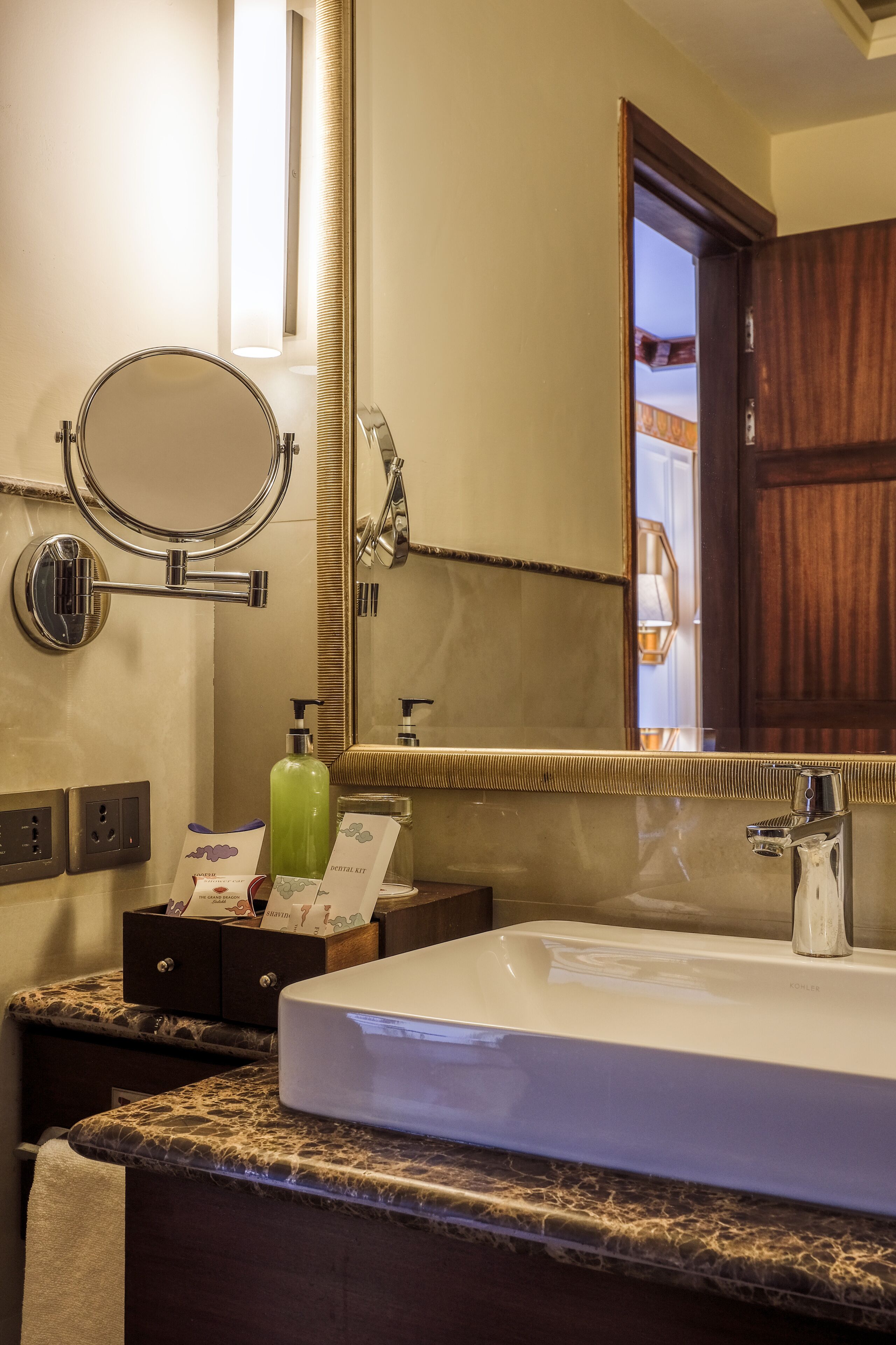 A bathroom with a large mirror, a white sink, and a vanity with a towel.