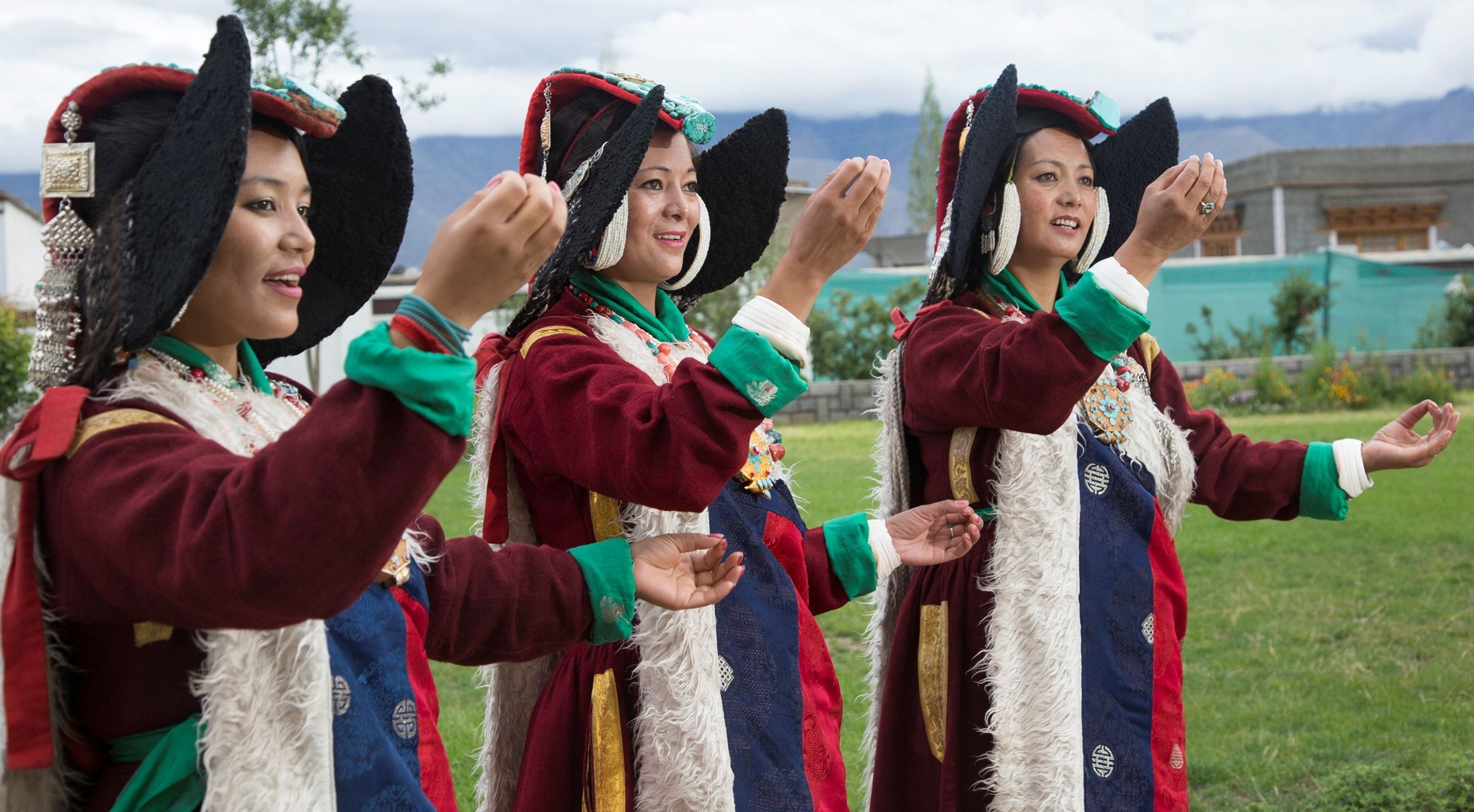 Un grupo de personas vestidas con trajes tradicionales al aire libre.