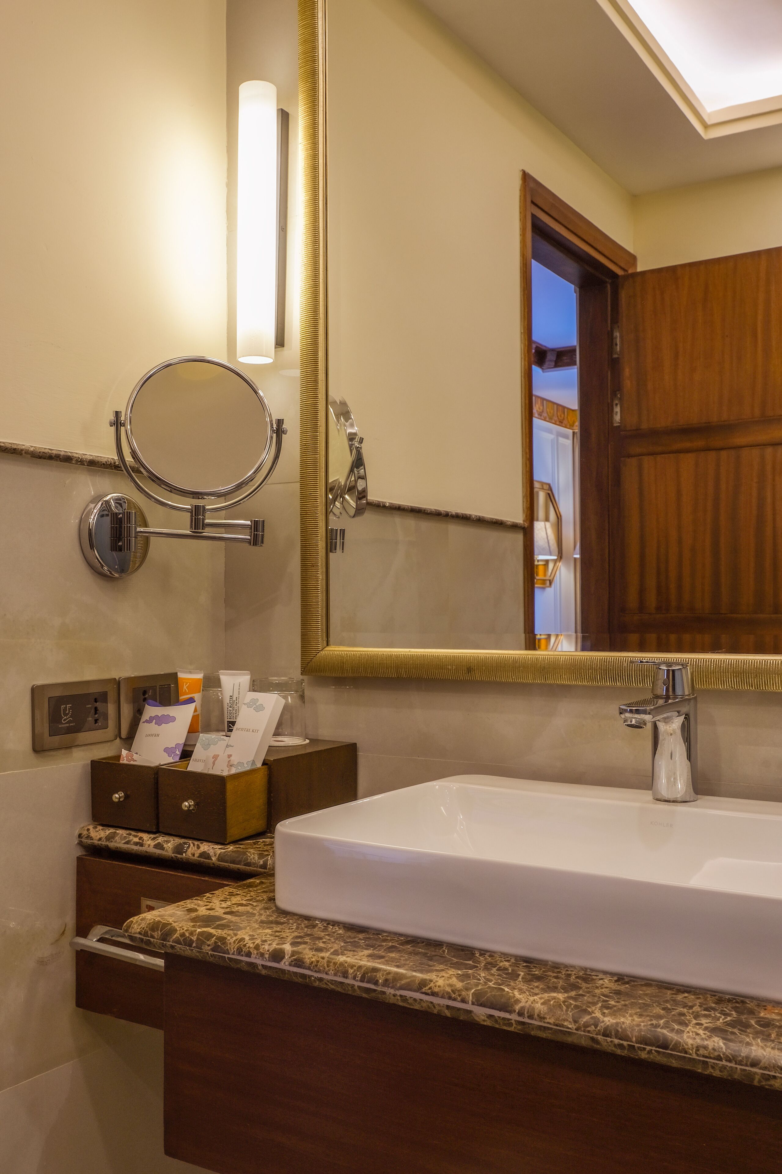 A bathroom with a white sink, a round mirror, and a wooden cabinet.