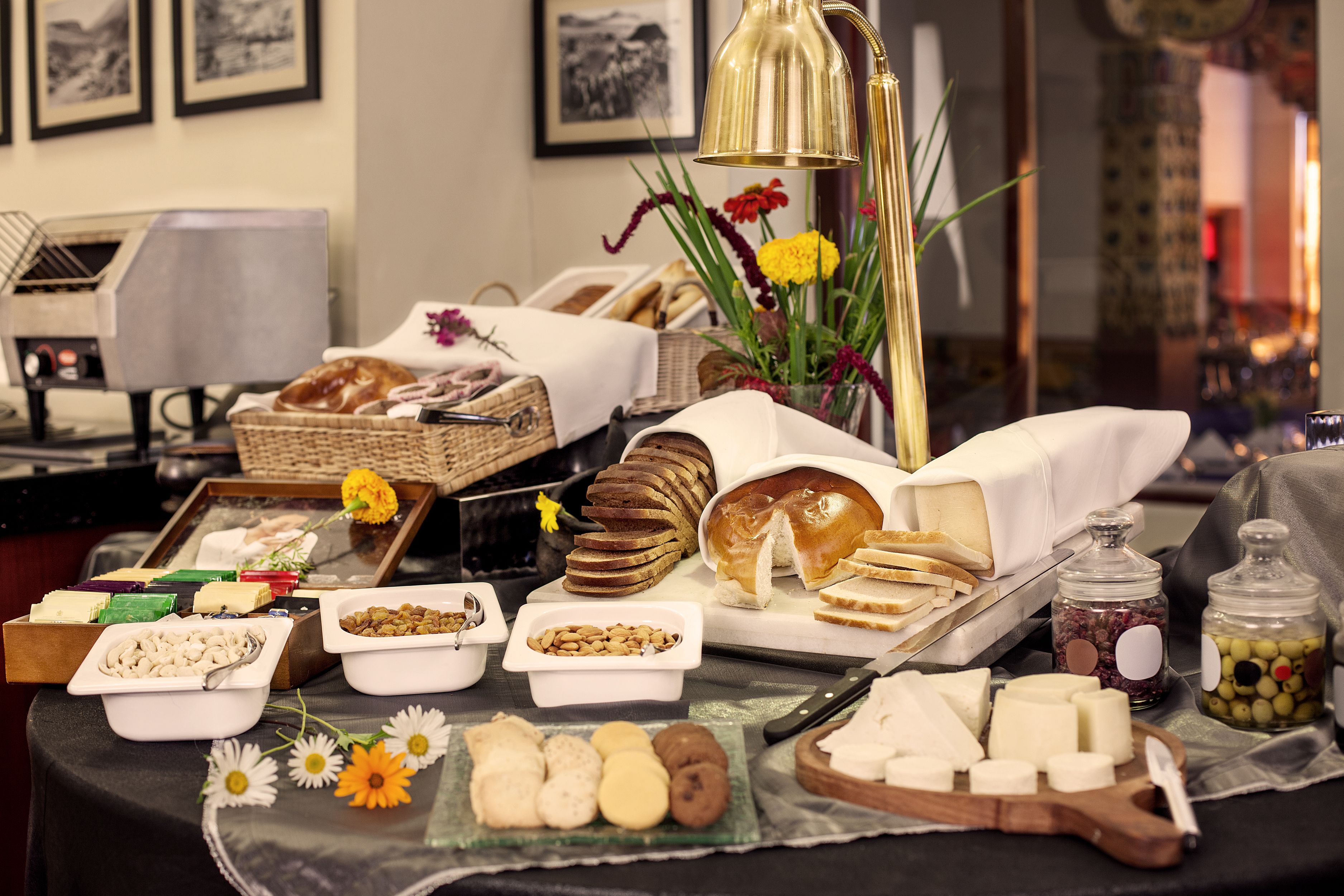 Una mesa de buffet con varios quesos, panes y pasteles.