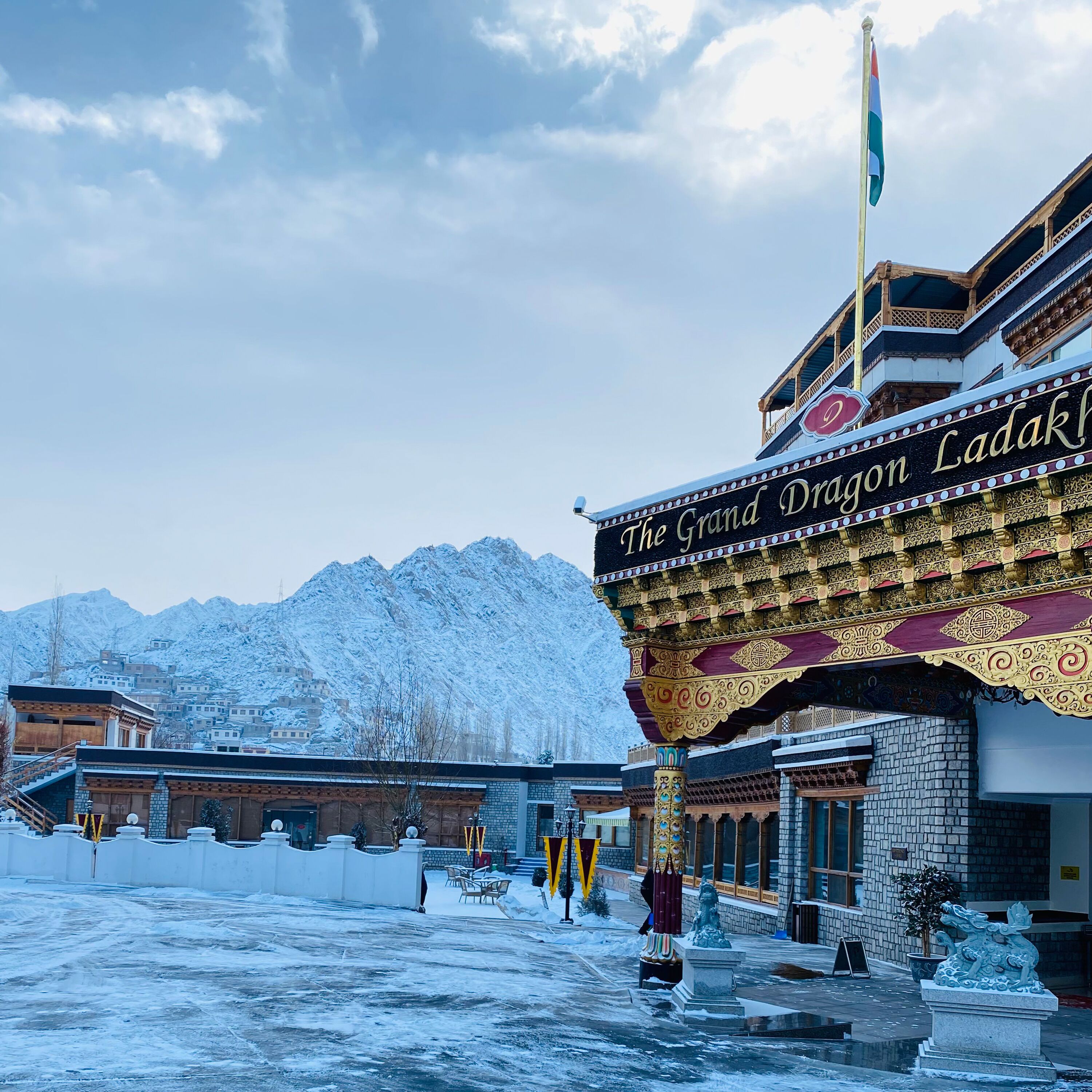 The Grand Dragon Ladak, a building with traditional architecture and a flagpole.