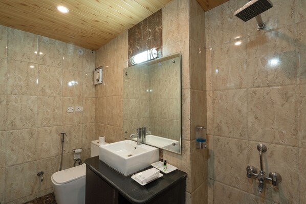 A modern bathroom with a wooden ceiling, a large mirror, a sink, a toilet, and a shower area.