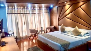 Un dormitorio con una cama grande, un escritorio, una silla y un ventilador de techo.