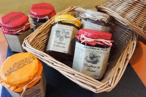 A wicker basket containing several small jars with labels, some tied with white strings. - Aviation Hotel (La Bourboule)