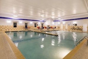 An indoor swimming pool with multiple lanes, surrounded by checkered walls and blue ceiling lights. - La Quinta Inn & Suites by Wyndham Fargo-Medical Center (Fargo)