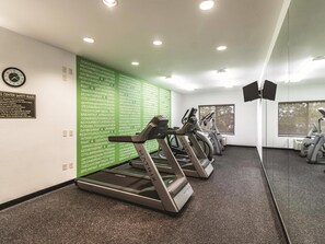 A gym with treadmills, a wall with motivational quotes, and a safety rule sign. - La Quinta Inn & Suites by Wyndham Fargo-Medical Center (Fargo)