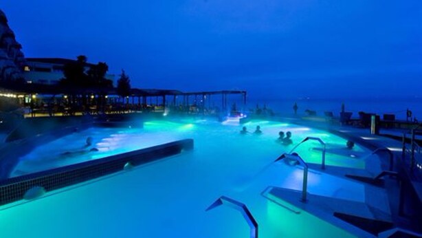 Ein Pool bei Nacht mit Blick auf das Meer.