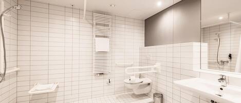 A modern bathroom with a toilet, sink, and shower.
