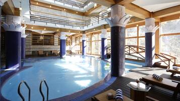 Una piscina techada, sillones reclinables de piscina