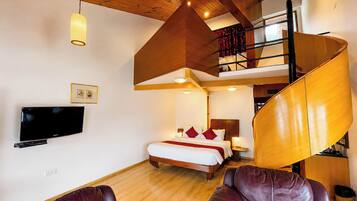 Quarto de hotel moderno com teto de madeira, cama com almofadas vermelhas, televisão e sofá de couro.