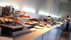 A buffet with various food items and a person in the background.