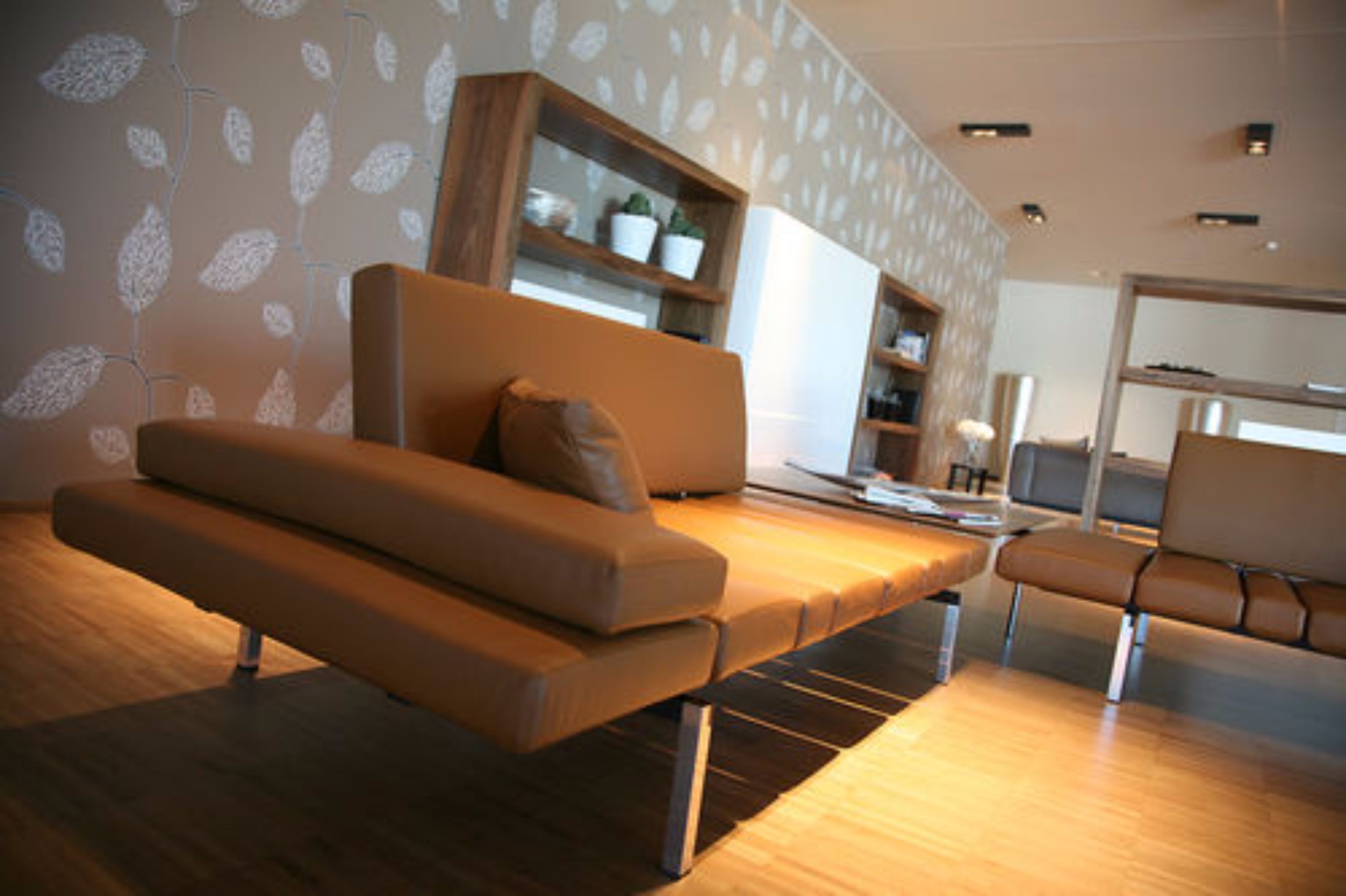A modern living room with a sofa, a coffee table, and a bookshelf.