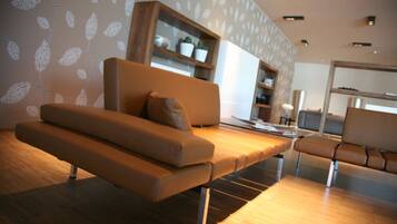 A modern living room with a sofa, a coffee table, and a bookshelf.