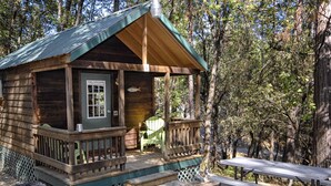 Eine Holzhütte mit Veranda, einer Bank und einem Picknicktisch.