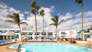 Ein Poolbereich mit Liegestühlen und Palmen, umgeben von einem Hotelgebäude mit dem Schriftzug "MONTANA CLUB".