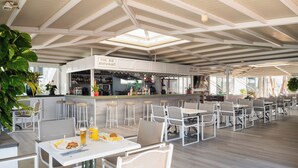 Ein geräumiger Innenbereich mit Essbereich, hohen Decken und Tageslicht, ausgestattet mit einer Poolbar und einem Restaurant.
