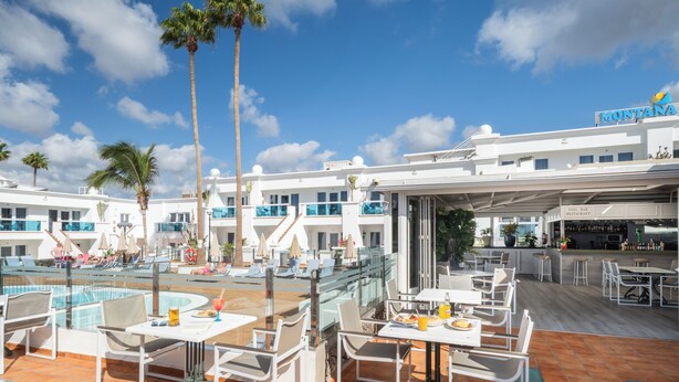 Ein Resort mit Poolbereich, Außenbereich zum Sitzen und einer Bar.