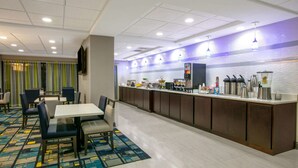 A hotel lobby with a long counter, seating area, and a patterned carpet. - La Quinta Inn & Suites by Wyndham Horn Lake / Southaven Area (Horn Lake)