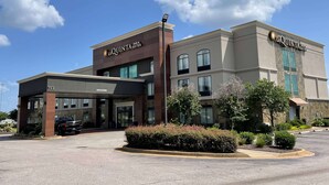 A hotel with a modern facade, multiple entry points, and a parking lot. - La Quinta Inn & Suites by Wyndham Horn Lake / Southaven Area (Horn Lake)