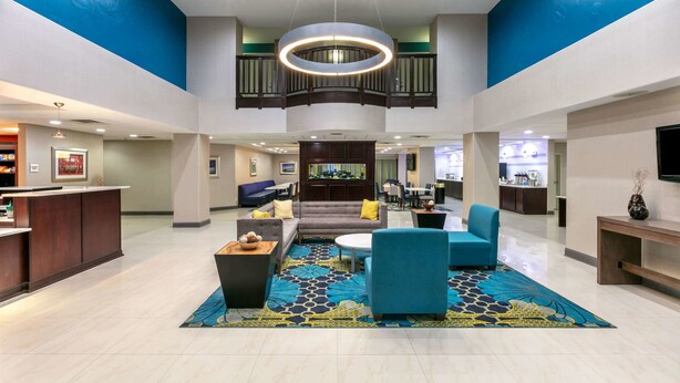 A spacious lobby with a central seating area, a reception desk, and a balcony. - La Quinta Inn & Suites by Wyndham Horn Lake / Southaven Area (Horn Lake)