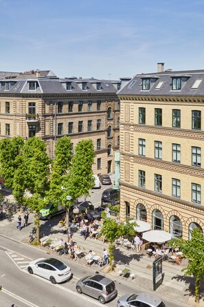 A street view with a row of buildings, trees, and parked cars. - Hotel Sct Thomas (Frederiksberg)