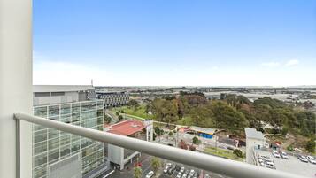 A high-rise building with a view of a parking lot and surrounding landscape.