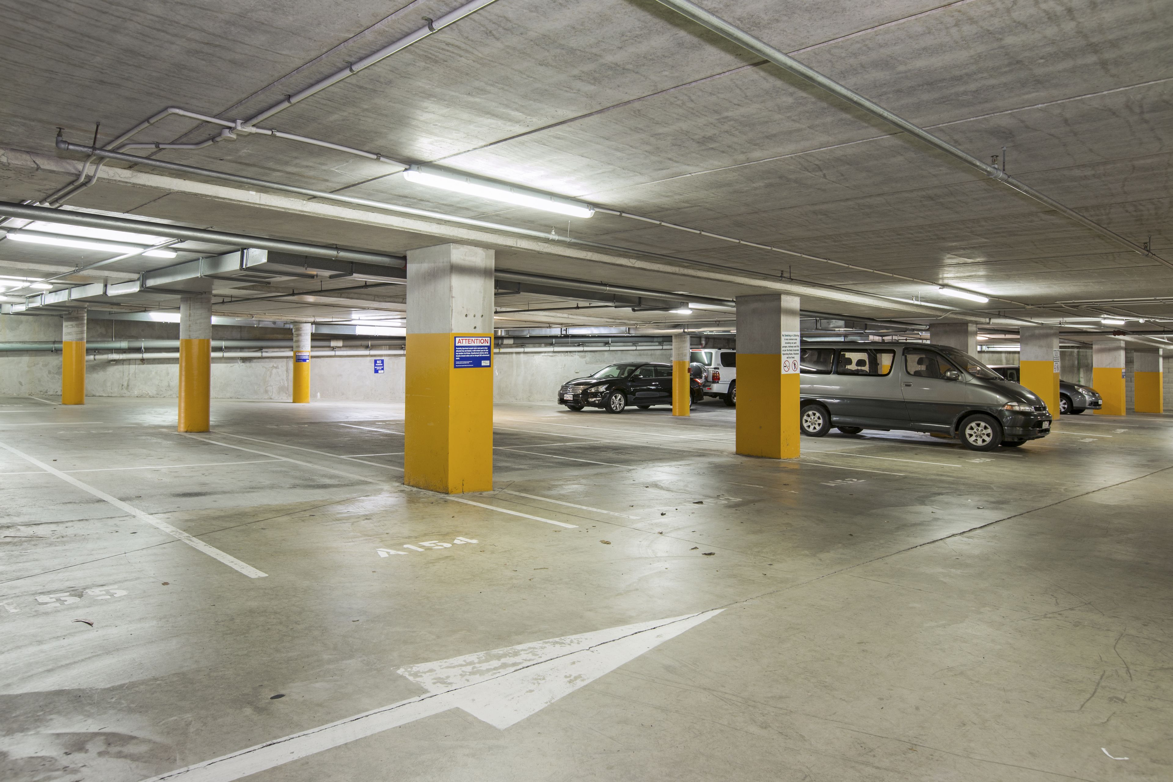 Un estacionamiento subterráneo de varios niveles, con pilares de hormigón y espacios delimitados.
