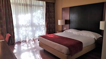 Una habitación de hotel con una cama, un escritorio y una silla.