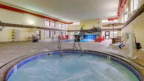 A swimming pool with a water slide, lounge chairs, and a sunbed area. - Stoney Creek Hotel Sioux City (Sioux City)