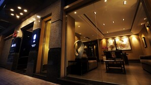 Un moderno vestíbulo de hotel con mostrador de recepción, zona de estar y una gran escultura abstracta.