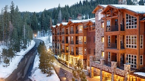 A multi-story lodge with stone and wood exterior, balconies, and a snow-covered road in the background. - Hyatt Vacation Club at Northstar Lodge, Lake Tahoe (Truckee)