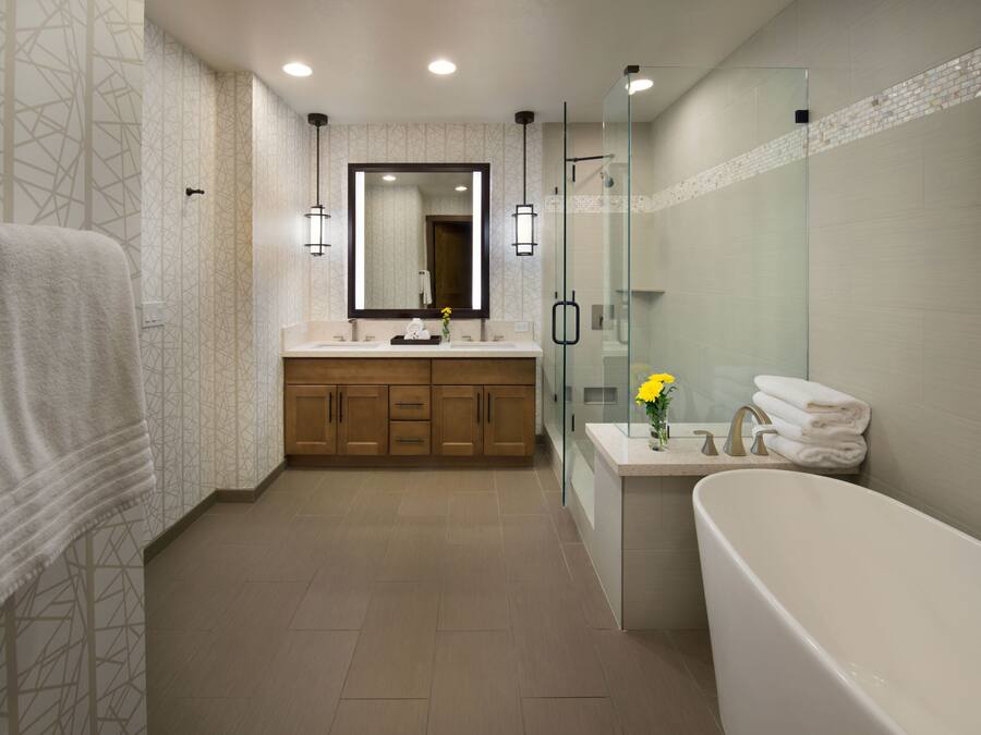 Une salle de bain moderne dotée d’une douche à parois de verre, d’une baignoire sur pieds et d’un meuble-lavabo avec un miroir.