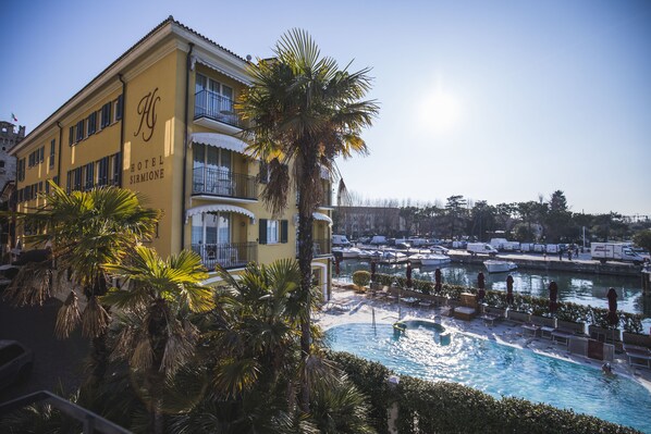 Un hotel con piscina, palmeras y cielo despejado.