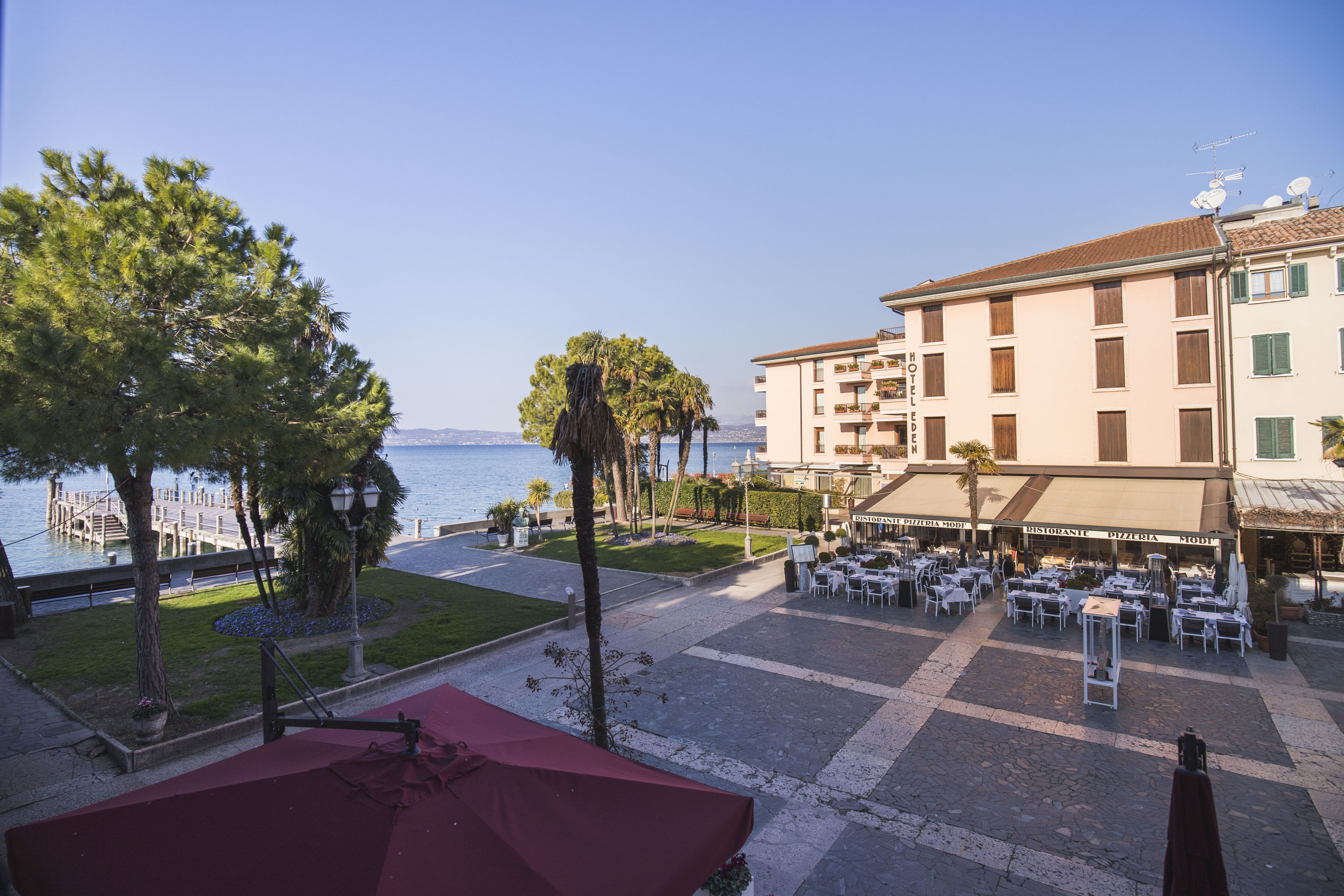 Hotel con terraza al aire libre y vista a un cuerpo de agua.