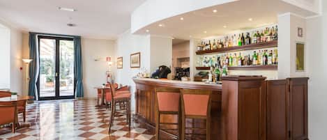 A bar area with a checkered floor, wooden bar counter, and multiple stools.