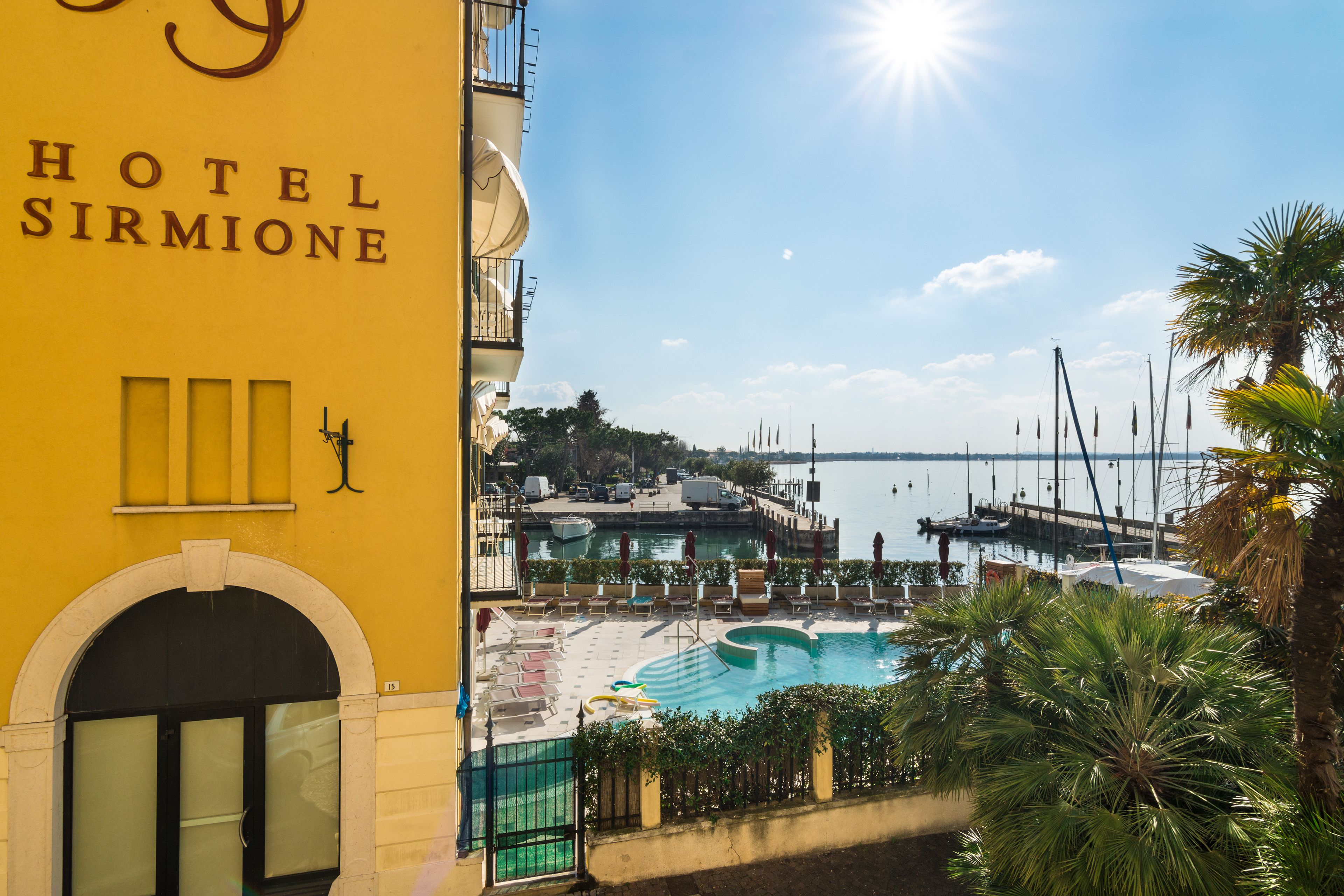 A hotel with a pool, a marina, and a clear view of the water.