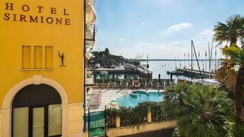 A hotel with a pool, a marina, and a clear view of the water.