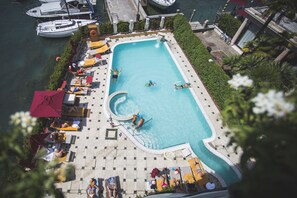 Una piscina al aire libre, sombrillas, tumbonas
