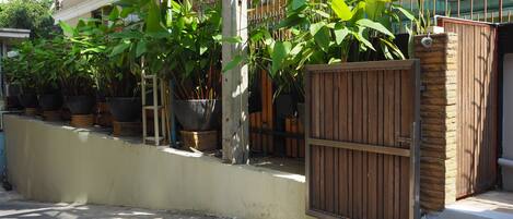 Un área cercada con plantas en macetas y una valla de madera.
