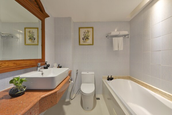 Un baño con lavamanos, inodoro y bañera.
